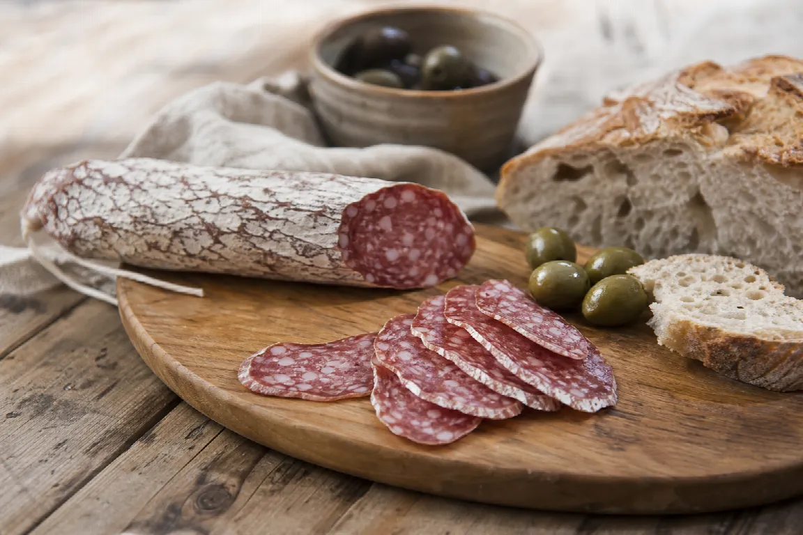 Skivad svensk salami upplagd i vifta på skärbräda